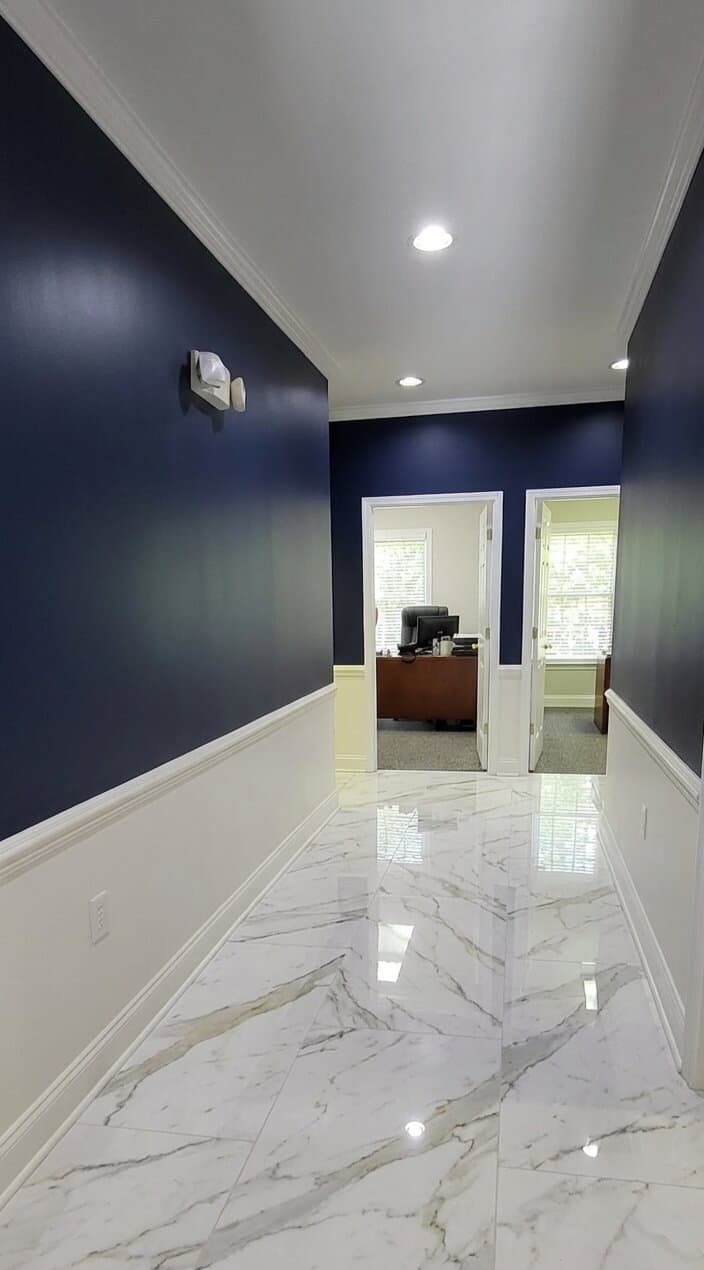 Premium commercial office hallway with deep navy walls and marble floors painted by Pro Araiza