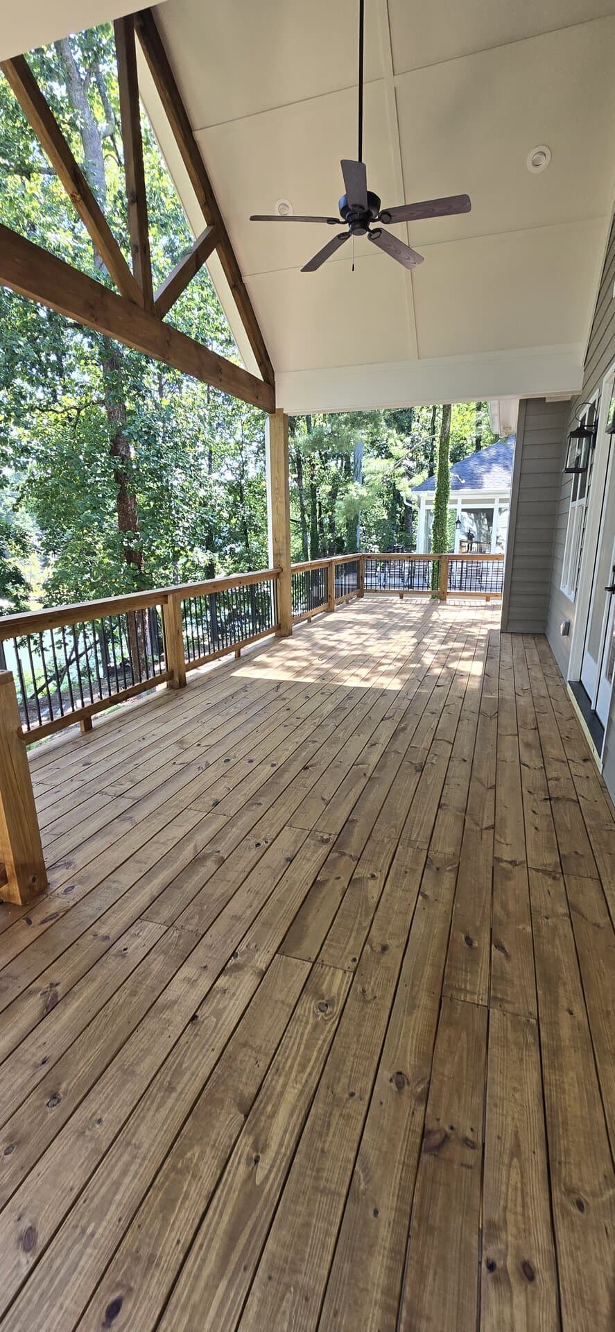 Custom timber-frame covered deck with exposed trusses and natural stained wood